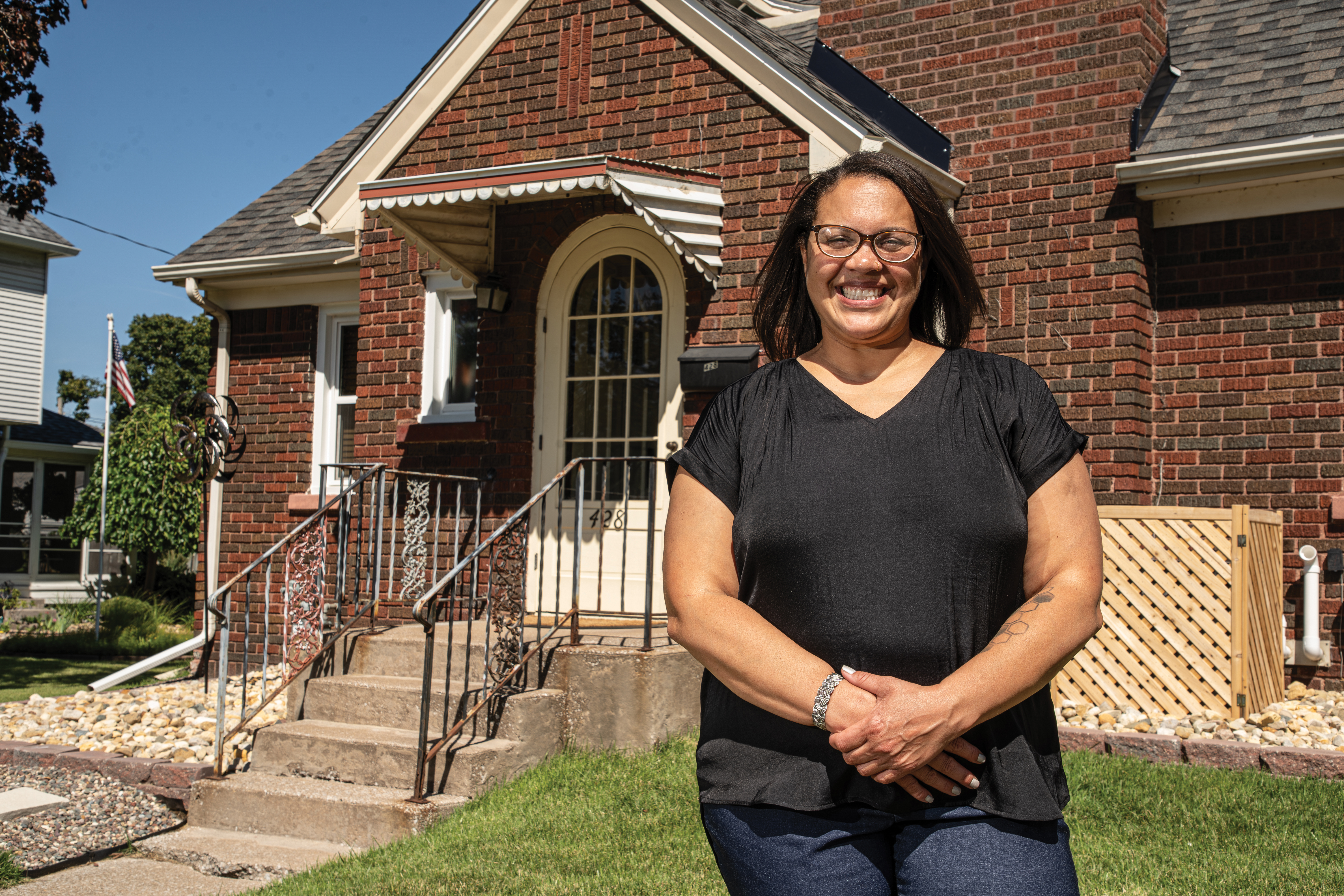 Woman smiling while standing in front of home