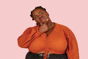 women wearing orange top thinking with a pink background