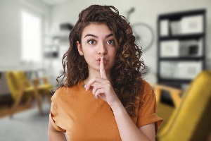 Young girl holding up her finger in a "shush" sign